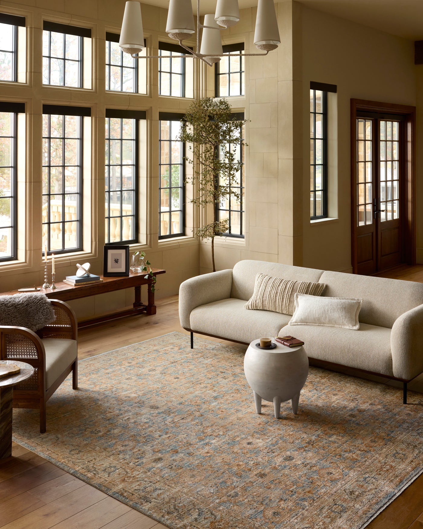Warm living room with neutral sofa, designer rug, natural wood tones, and soft layered decor