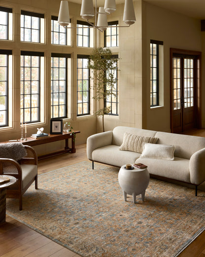 Warm living room with neutral sofa, designer rug, natural wood tones, and soft layered decor