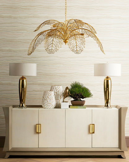Gold statement chandelier styled with wallpaper, lamps, and curated decor