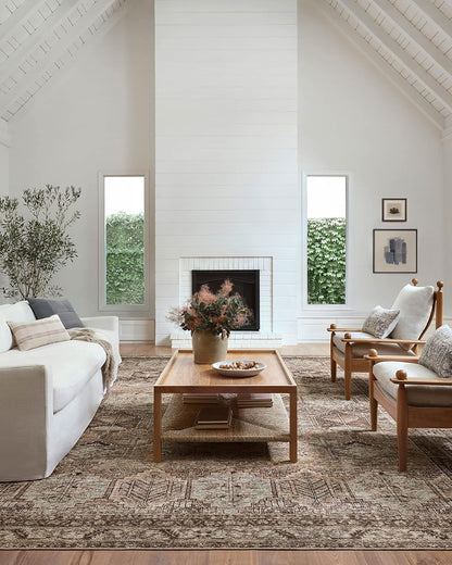 Bluffton-inspired living room with neutral seating, wood ceiling, white fireplace, and layered designer rug.