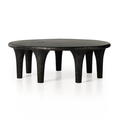 Round black table with unique legs on a white background