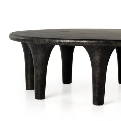 Black round table with unique legs on a white background